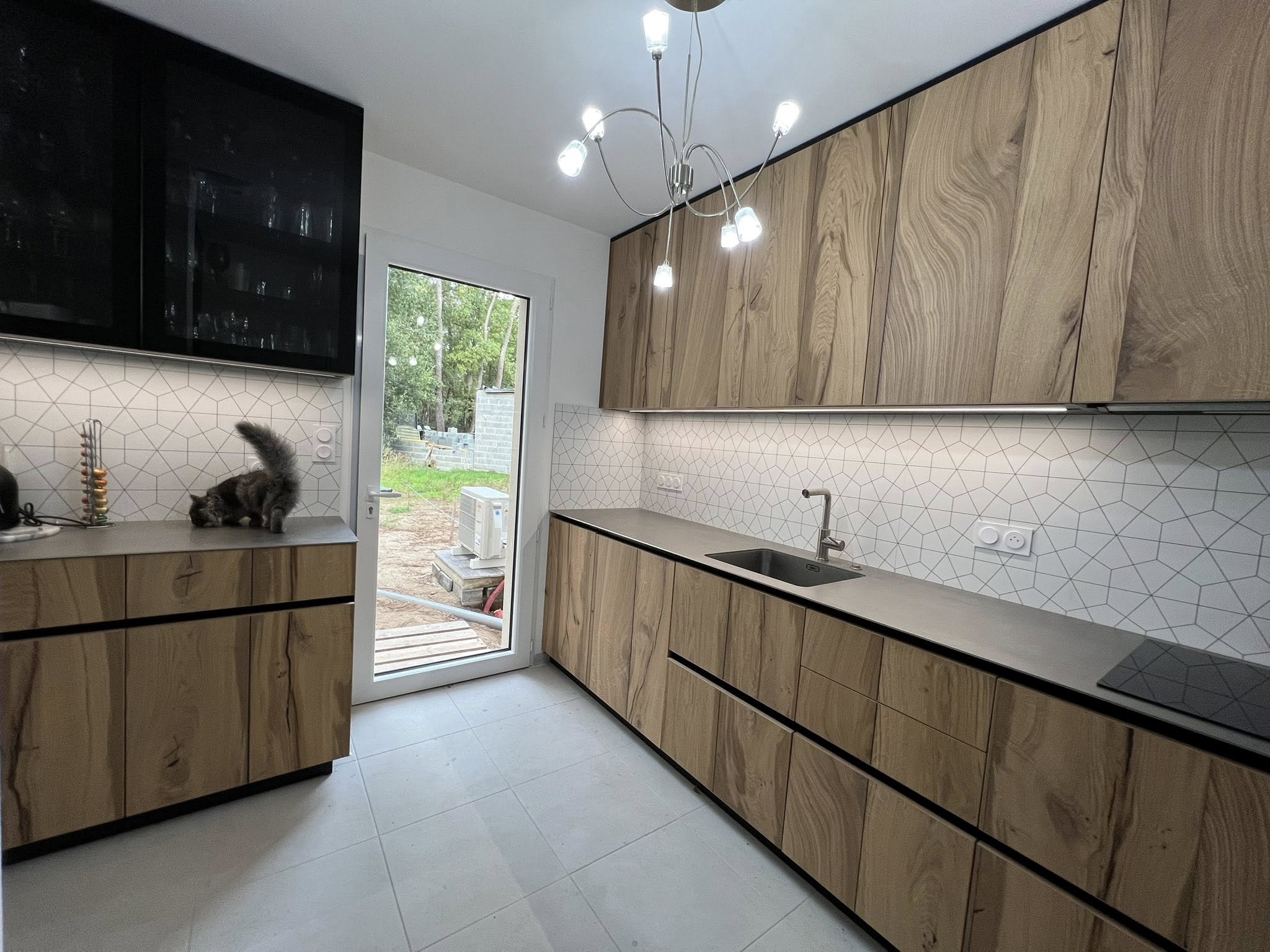 Cuisine façades en chêne naturel, colonnes noires intégrées et plan de travail gris