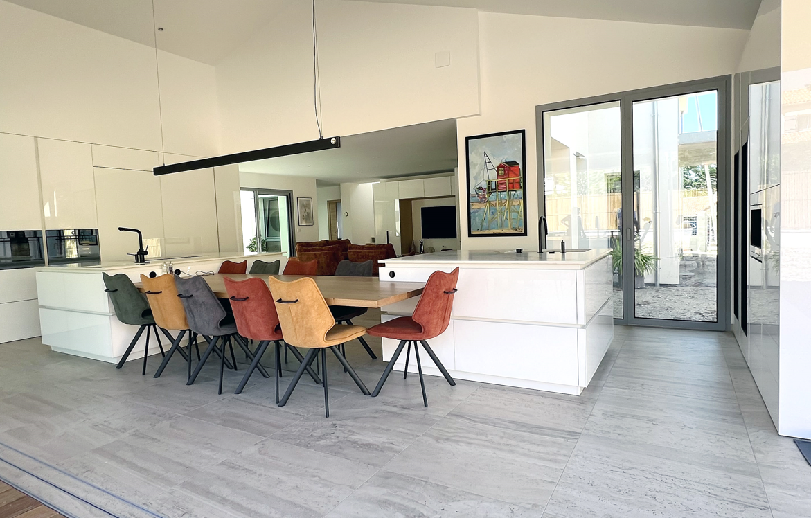 cuisine ancenis haut de gamme avec table integré entre deux ilots neolith