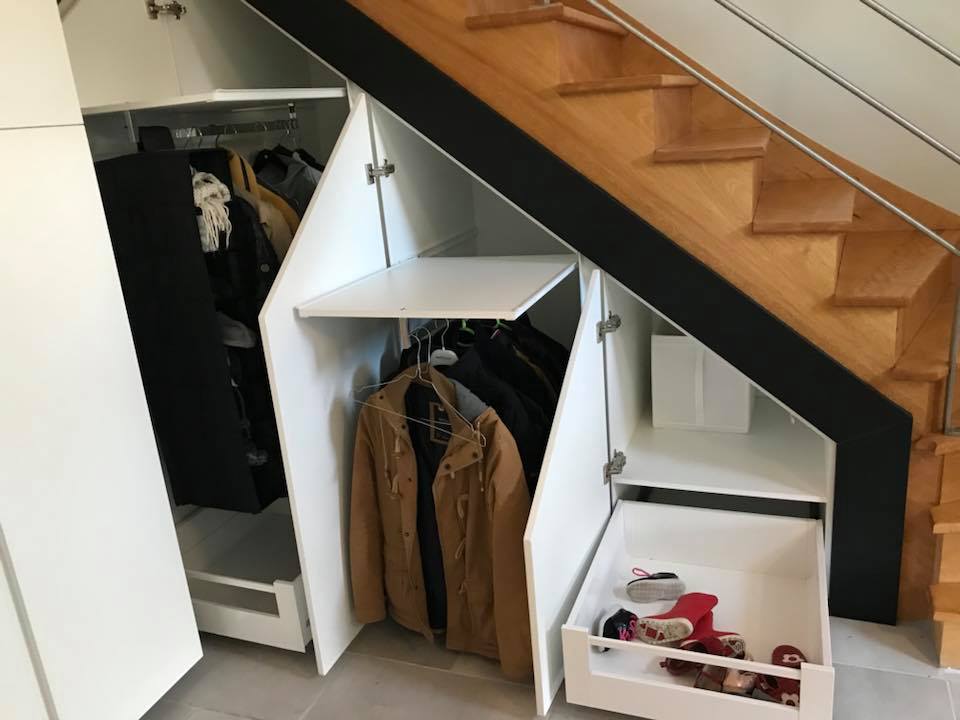 rangements aménagés dans un placard sous escalier dans l'entrée