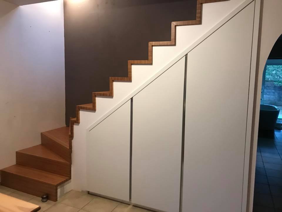 placard sous escalier en biseau avec passage en arche vers la salle à manger